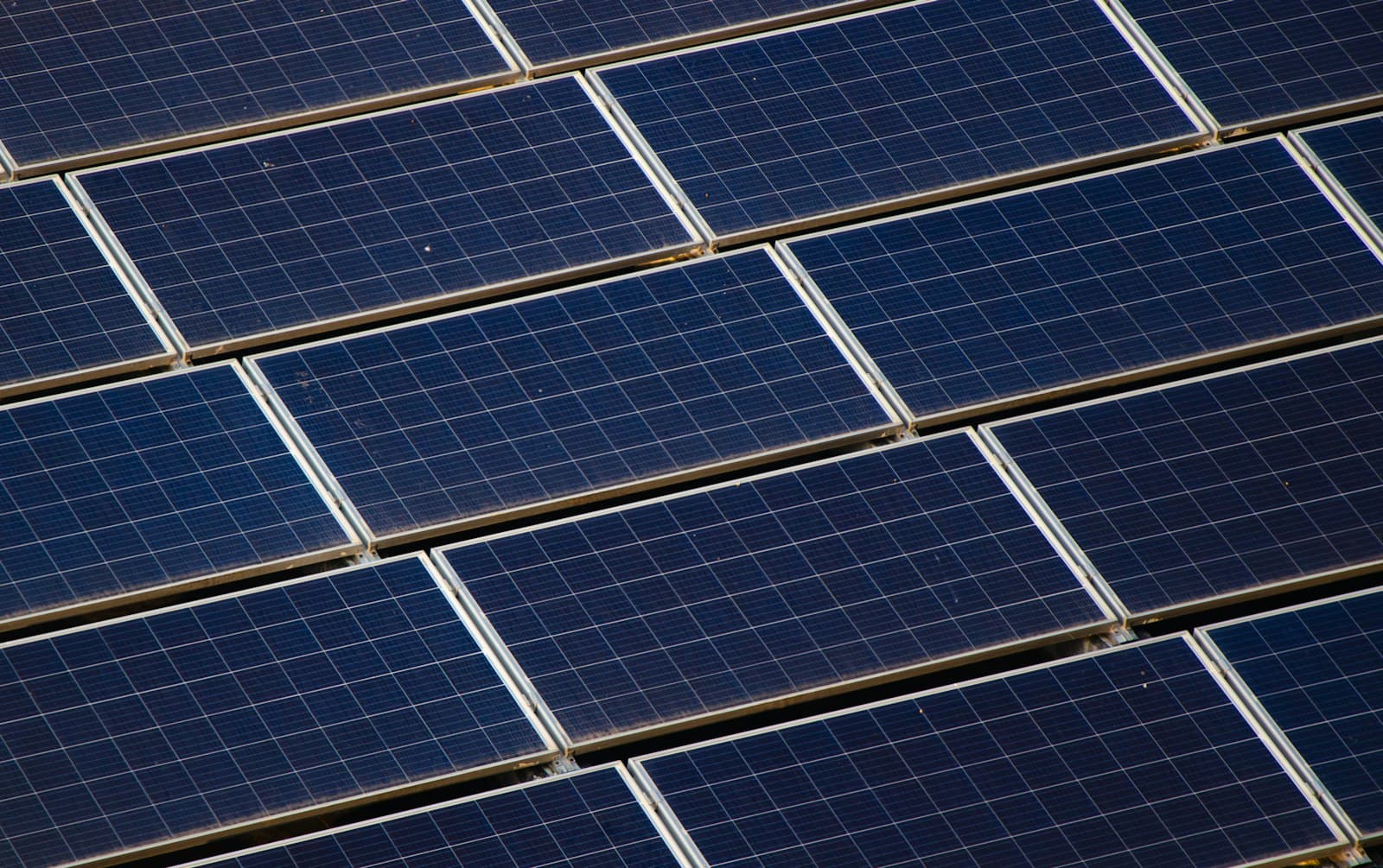 Photo d’illustration : panneaux photovoltaïques installés en toiture d’un bâtiment, vus en plongée.