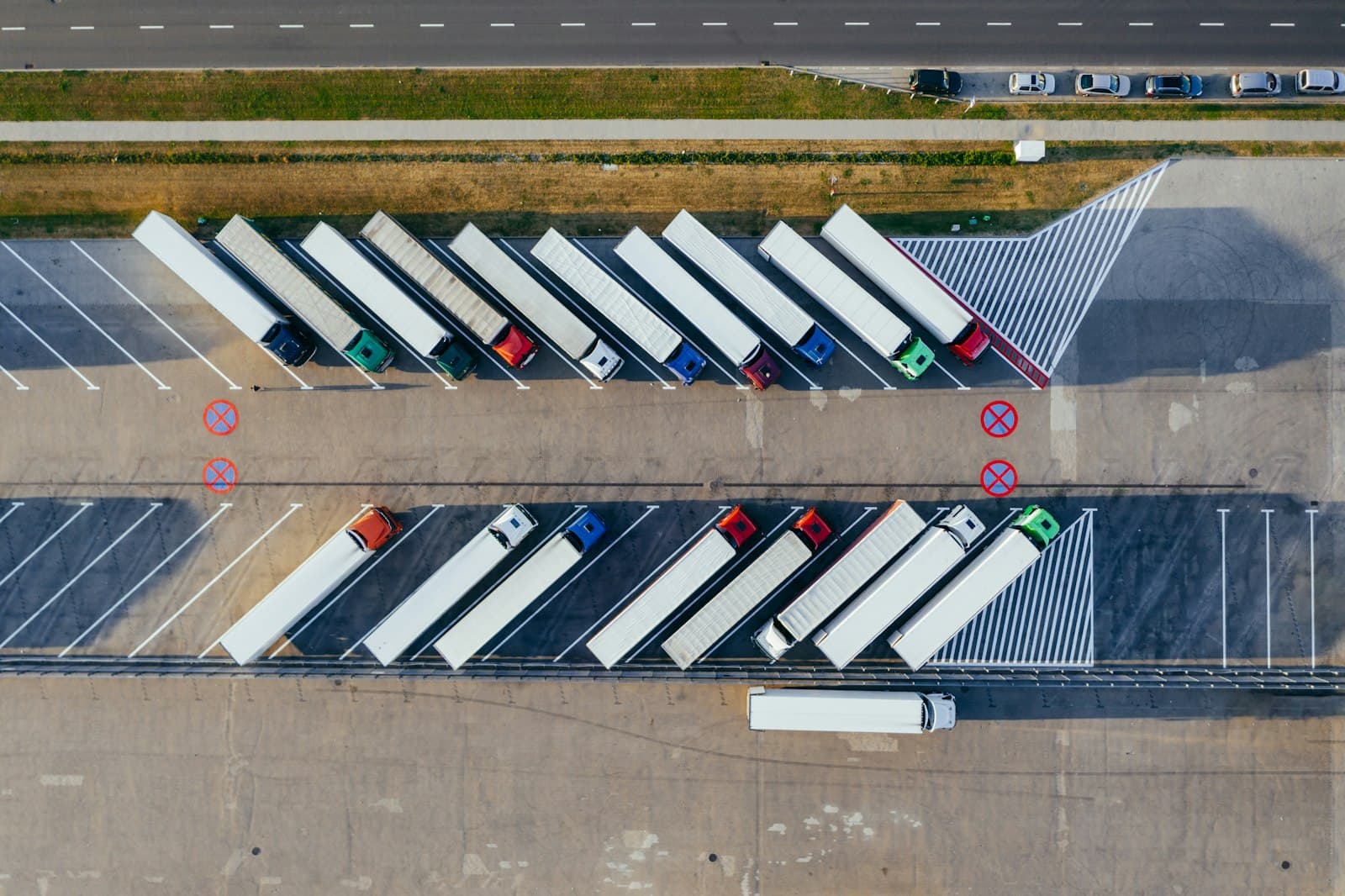 Photo d’illustration : vue aérienne de semi-remorques rangés le long d’une rangée de quais de chargement.